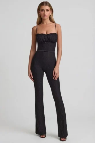 Arlena Jumpsuit mit Schleifendetail und ausgestellter Passform aus Spitze in Schwarz Arlena Jumpsuit mit Schleifendetail und ausgestellter Passform aus Spitze in Schwarz