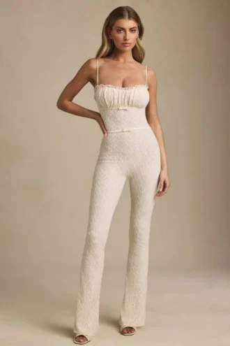Arlena Jumpsuit mit Schleifenverzierung und ausgestellter Passform aus Spitze in Elfenbein Arlena Jumpsuit mit Schleifenverzierung und ausgestellter Passform aus Spitze in Elfenbein