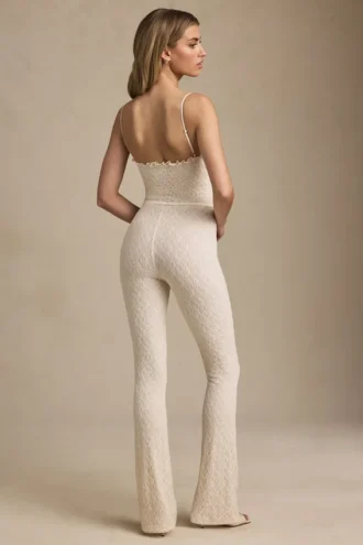Arlena Jumpsuit mit Schleifenverzierung und ausgestellter Passform aus Spitze in Elfenbein Arlena Jumpsuit mit Schleifenverzierung und ausgestellter Passform aus Spitze in Elfenbein
