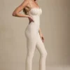 Arlena Jumpsuit mit Schleifenverzierung und ausgestellter Passform aus Spitze in Elfenbein Arlena Jumpsuit mit Schleifenverzierung und ausgestellter Passform aus Spitze in Elfenbein