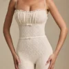 Arlena Jumpsuit mit Schleifenverzierung und ausgestellter Passform aus Spitze in Elfenbein Arlena Jumpsuit mit Schleifenverzierung und ausgestellter Passform aus Spitze in Elfenbein